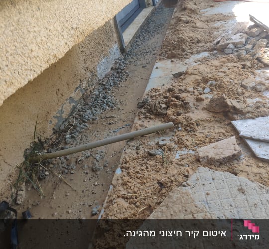 חפירה ליד קיר עם חצץ ואדמה